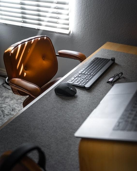 Desk with keyboard and mouse and empty chair